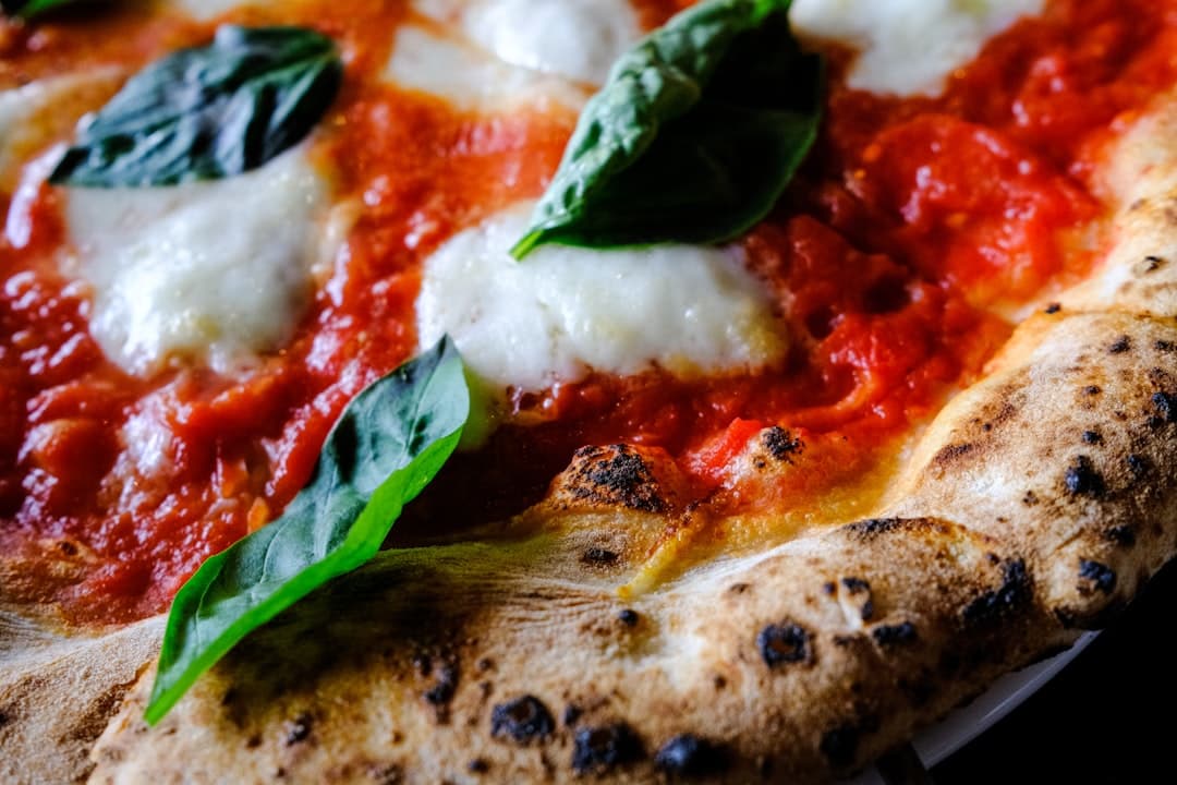 Närbild på en pizza med basilika och mozzarella
